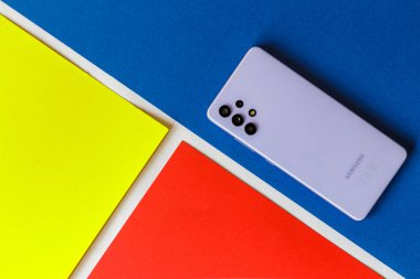 Zaporozhye Ukrayna - 12 Ağustos 2021: Samsung gökadası A32 mavi bir arka planda izole edildi. Üst arka görünüm.