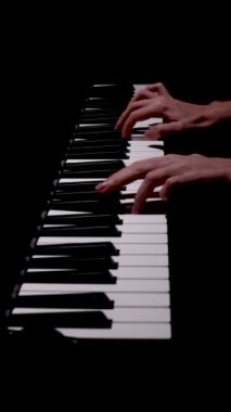 Kadın piyanist elleri yakın çekimde güzel bir kuyruklu piyanoda klasik müzik çalar. Piyano tuşları koyu renklerde kapanır. Öğrenci piyano çalmak için eğitim alır. Müzik okulu. Filarmoni.