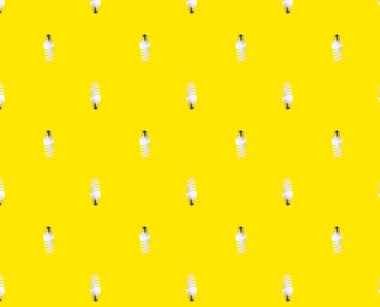 Enerji tasarrufu kavramı. Sarı arka planda floresan lambaların kusursuz deseni.
