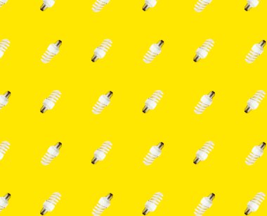 Enerji tasarrufu kavramı. Sarı arka planda floresan lambaların kusursuz deseni.