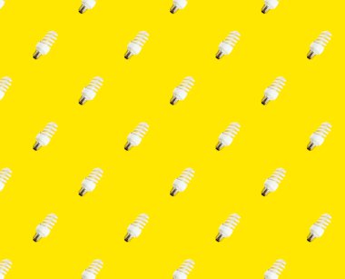 Enerji tasarrufu kavramı. Sarı arka planda floresan lambaların kusursuz deseni.