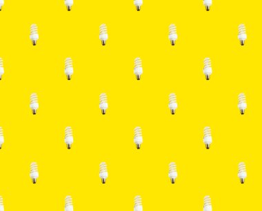 Enerji tasarrufu kavramı. Sarı arka planda floresan lambaların kusursuz deseni.
