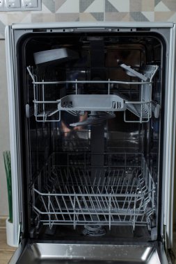 Bulaşık makinesini aç. Ev sahibesi bulaşık makinesine kirli bulaşıkları koymaya hazırlanıyor..