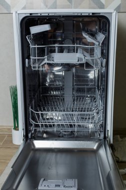 Bulaşık makinesini aç. Ev sahibesi bulaşık makinesine kirli bulaşıkları koymaya hazırlanıyor..