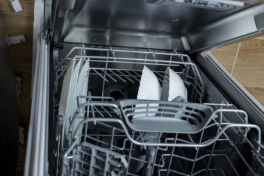 clean dishes in the dishwasher basket. Cleaning the house and washing dishes in the dishwasher.