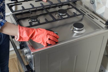 modern gas oven girl washes the gas oven. Cleaning in the kitchen.