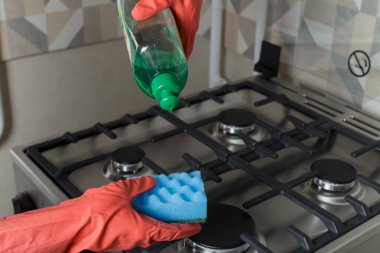 Kız fırını yıkamak için süngerden deterjan alıyor. Mutfakta temizlik..