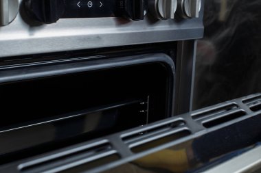 a woman in red rubber gloves cleans a gas stove. cleaning in the kitchen.