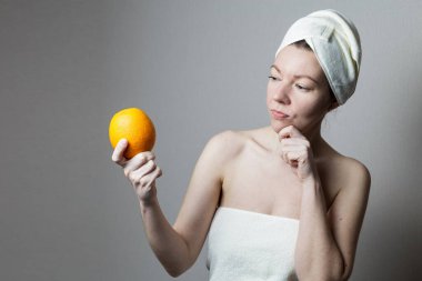 Portakal tutan havlulu bir kız.