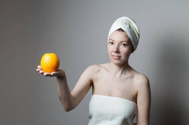 Portakal tutan havlulu bir kız.