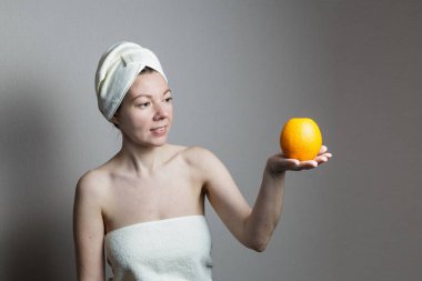 Portakal tutan havlulu bir kız.