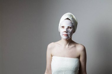 Kaplıca salonunda kumaş maskeli çekici bir kadın. yüz bakımı konsepti.