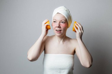 Güzel bir kadın göz bandı kullanır. Kadın gülümsüyor ve portakalın iki yarısını kulaklık gibi tutuyor. Bir kadın müzik dinler. Banyodan sonra dinlen.