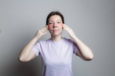 Güzel bir kız estetik ameliyat yapar. Kız göz bandı kullanıyor. Gözlerinin altındaki cilt bakımı.