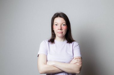 Güzel bir kız estetik ameliyat yapar. Kız göz bandı kullanıyor. Kadın kollarını göğsünün üzerinde kavuşturdu. Güvensizlik durumu.