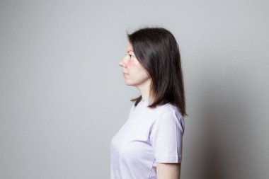 Güzel bir kız estetik ameliyat yapar. Yan görünüş. Gözlerinin altındaki cilt bakımı.