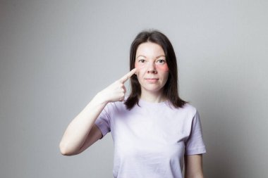 Güzel bir kız estetik ameliyat yapar. Kız göz bandı kullanıyor. Kadın göz bandını işaret ediyor