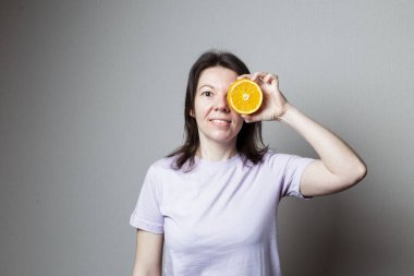 Elinde portakal tutan genç bir kadın. Sağlıklı gıda konsepti