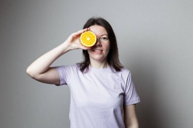 Elinde portakal tutan genç bir kadın. Sağlıklı gıda konsepti