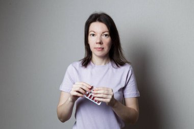 Elinde bir paket hap tutan çekici bir kadın.