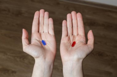 Kırmızı ve mavi haplar. Elinde kırmızı ve mavi haplar tutan bir kız.