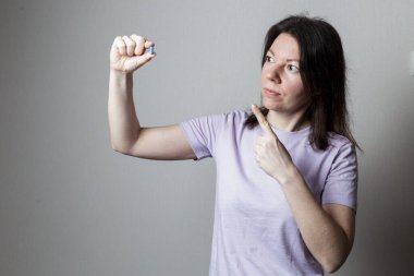 Elinde kırmızı bir hap tutan kız.