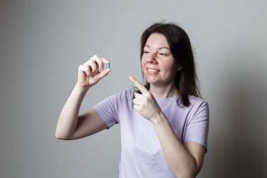 Elinde kırmızı bir hap tutan kız.