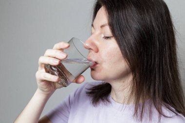 Bir kadın bardaktan temiz su içer. sağlıklı gıda konsepti