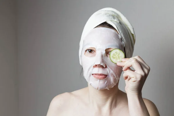 Wellness Behandlungen Ein Mädchen Mit Kosmetikmaske Einem Wellnesssalon Hält Gurkenscheiben — Stockfoto