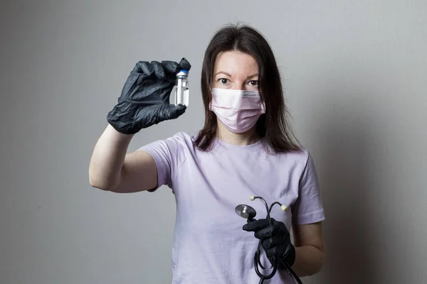 Μια Γυναίκα Γιατρός Μαύρα Γάντια Και Φωνοσκόπιο Κρατά Ένα Μπουκάλι — Φωτογραφία Αρχείου