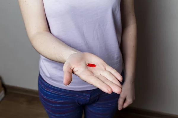 Девушка Держит Красную Таблетку Руке — стоковое фото