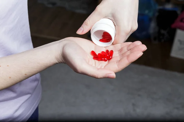 Meisje Giet Rode Pillen Uit Een Pot Haar Hand — Stockfoto