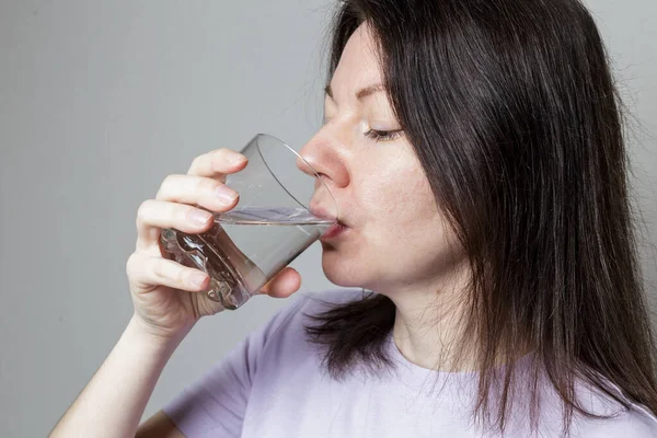 Bir kadın bardaktan temiz su içer. sağlıklı gıda konsepti