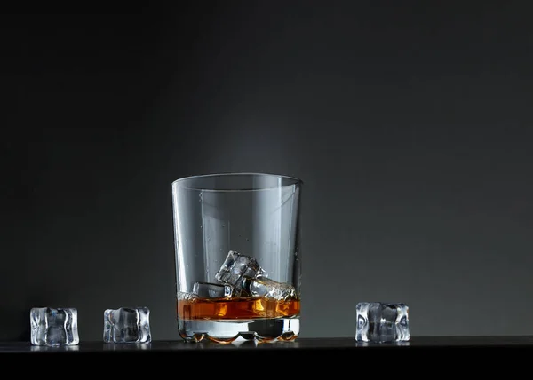 暗い氷の上にウイスキーのグラスが — ストック写真