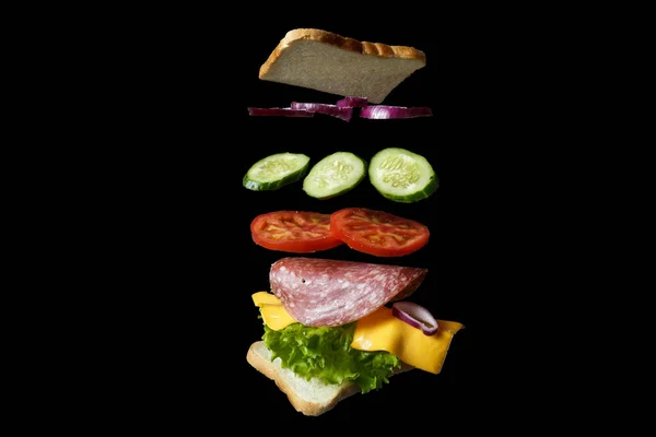 Vliegende Sandwich Brood Met Ham Tomaat Salade Geïsoleerd Zwart — Stockfoto