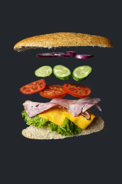 Vliegende Sandwich Brood Met Ham Tomaat Sla Geïsoleerd Grijs — Stockfoto