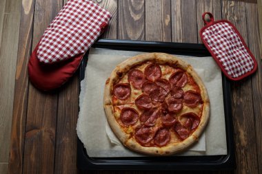 Ahşap arka plan üzerinde taze pişmiş pizza