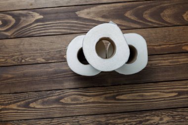 Tahta bir arka planda tuvalet kağıdı ruloları.