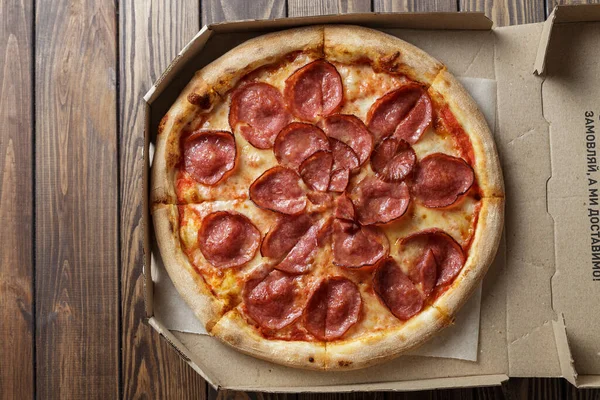 Ahşap arka planda pepperoni pizza.