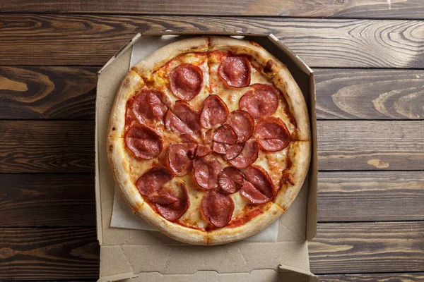 Ahşap arka planda pepperoni pizza.