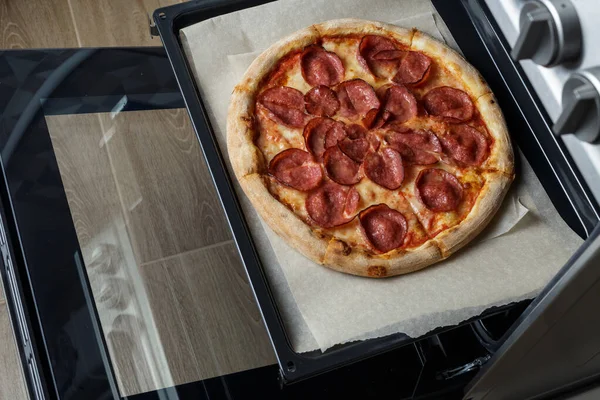 Fırında pişmiş pepperonili pizza. Pizza fırından çıktı.