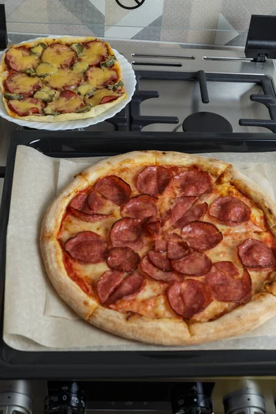 Fırında yeni pişmiş pizza. İki çeşit pepperoni pizza ve salam. Ev yapımı pizza.