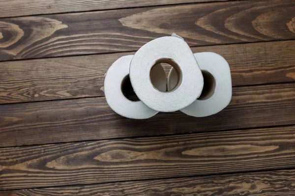 Tahta bir arka planda tuvalet kağıdı ruloları.
