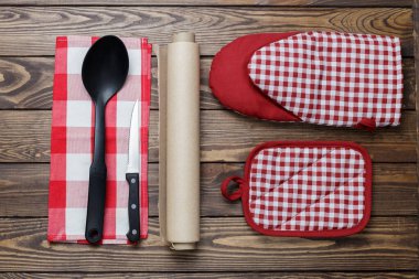 Mutfak aletleri konsepti. Tutacağı, fırın kağıdı, fırın kağıdı ve ahşap bir arka planda bir kepçe..