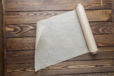 Ahşap bir arka planda kağıt yapmak. Bir rulo kağıt açıyorum..