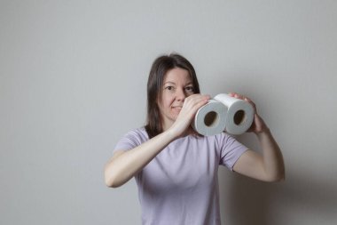 toilet paper concept. beautiful girl in a good mood, smiling, pretending to have toilet paper glasses