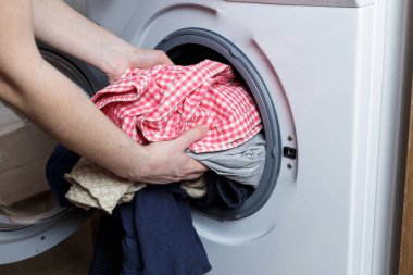 Çamaşır yıkama kavramı. Kız çamaşır makinesini yüklüyor..