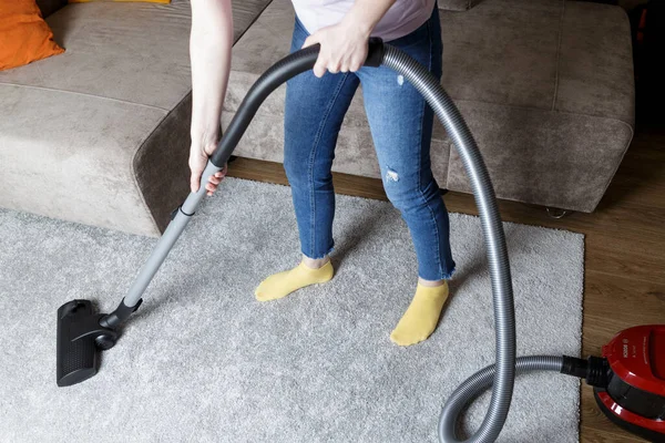 Een Meisje Een Blauwe Spijkerbroek Stofzuigt Het Tapijt Huisreiniging — Stockfoto