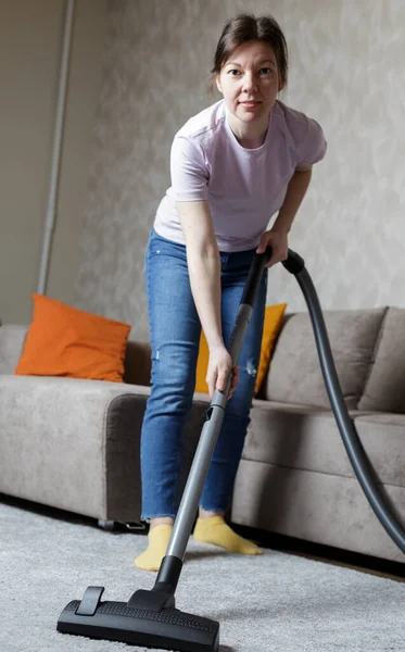 Una Chica Pantalones Vaqueros Azules Aspira Alfombra Limpieza Casa — Foto de Stock