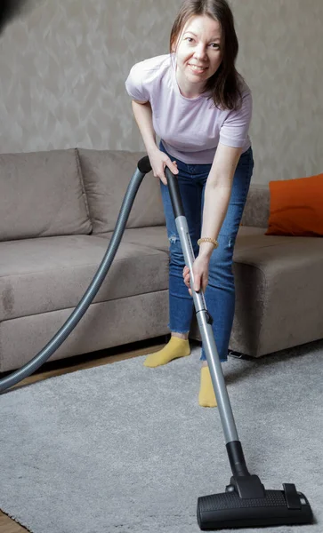 Mooi Lachend Meisje Een Meisje Een Blauwe Spijkerbroek Stofzuigt Het — Stockfoto